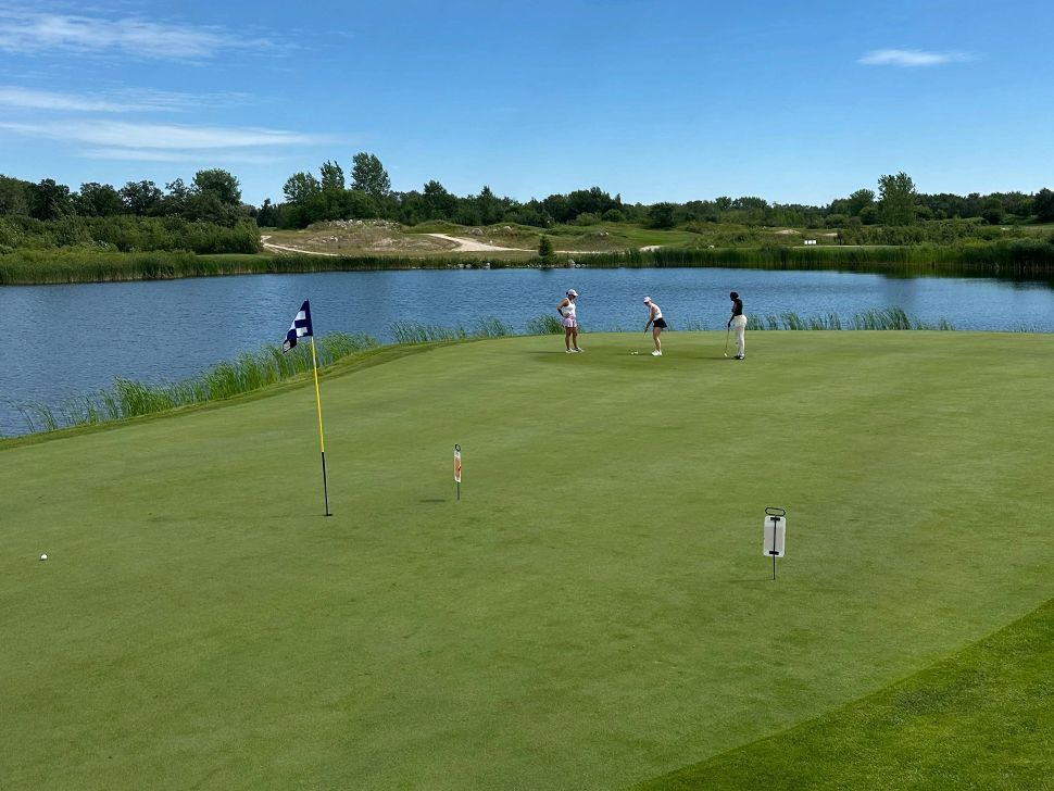 people on a golf course with water behind